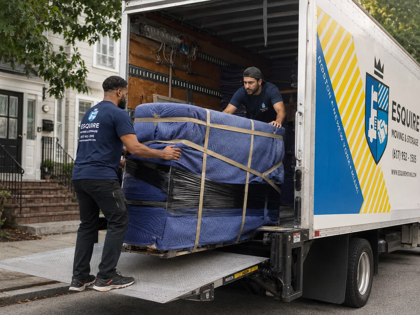 Esquire movers loading furniture protected with moving blankets and wrap into a branded truck