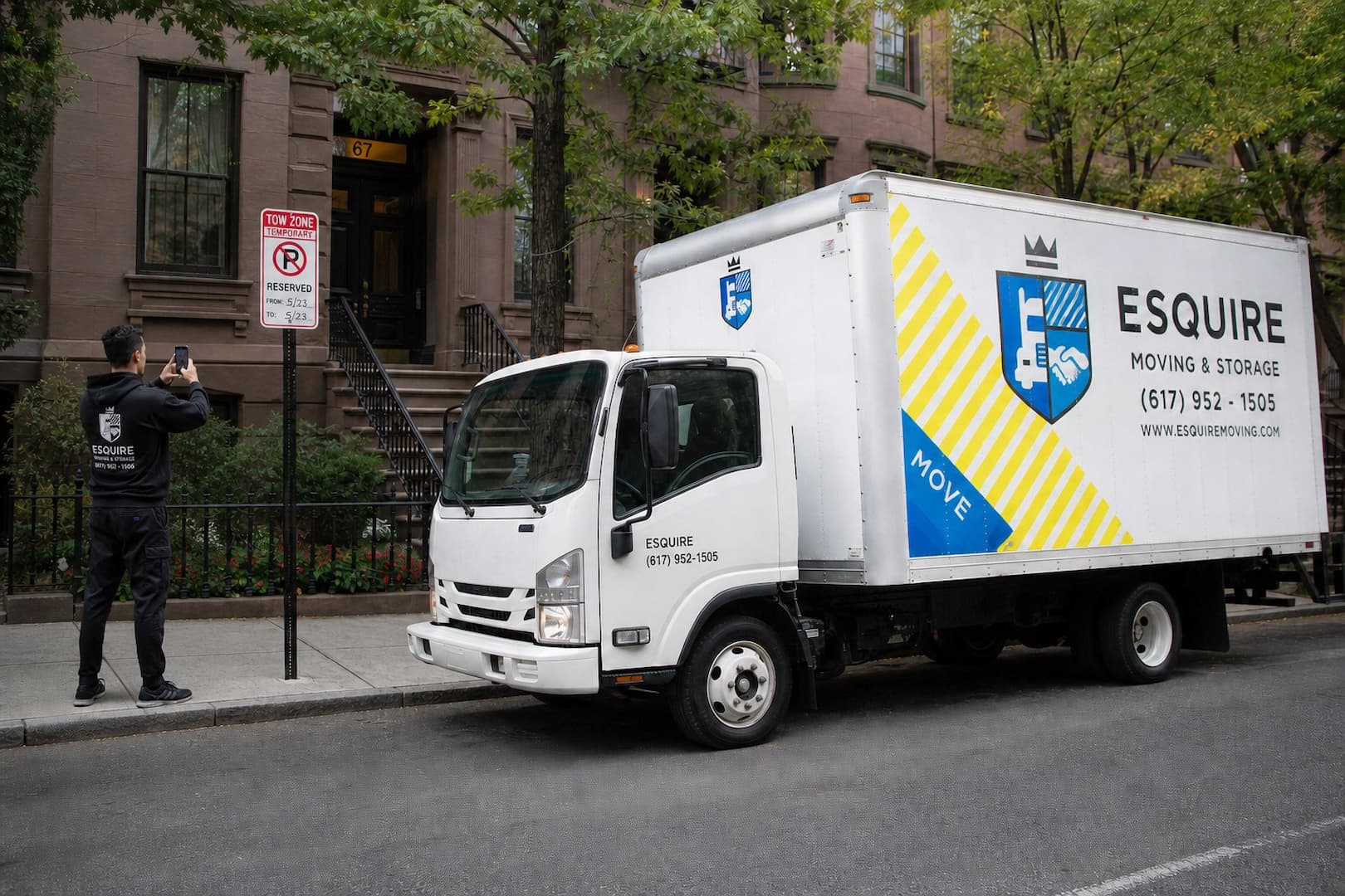 Esquire mover documenting a posted parking reservation sign beside a Boston moving truck