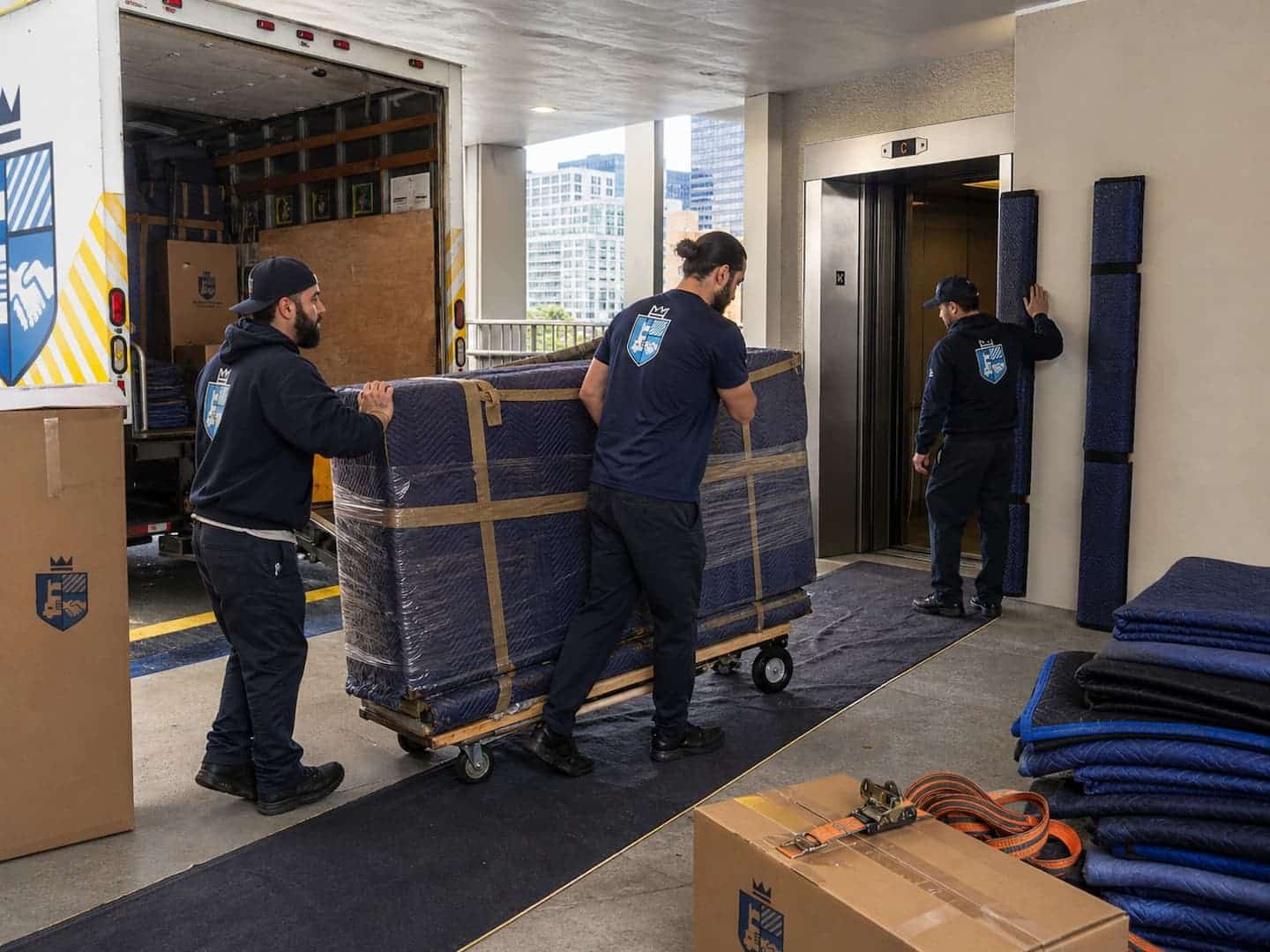Esquire movers guiding protected furniture from a Chicago high-rise loading dock to the moving truck